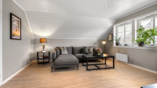 Loftstuen har panel i taket og laminat på gulvet.