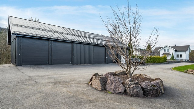 Den store driftsbygningen inneholder garasje, lager og treningsrom.
