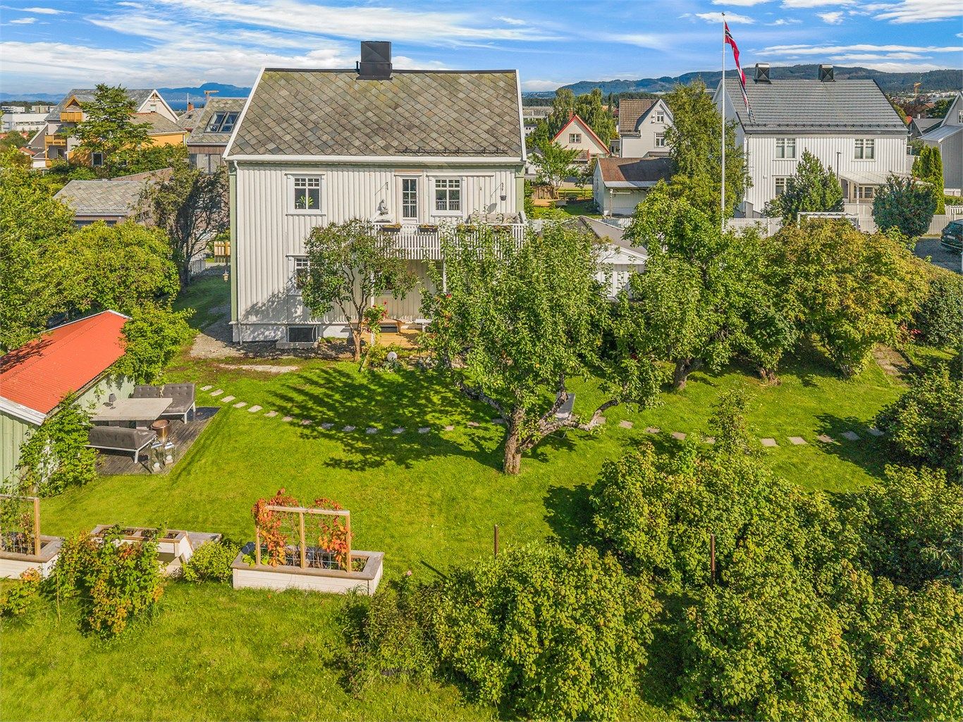 Fra luften får man et godt inntrykk av den romslige tomten og den flotte hagen som omkranser boligen.