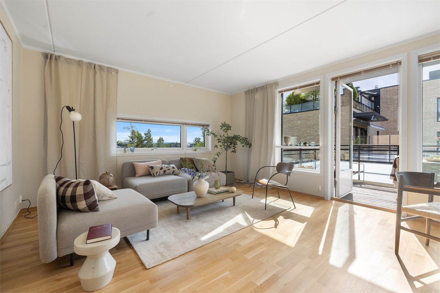 Leiligheten har en luftig stue med store vindusflater og direkte adkomst til balkongen som forlenger stuen.