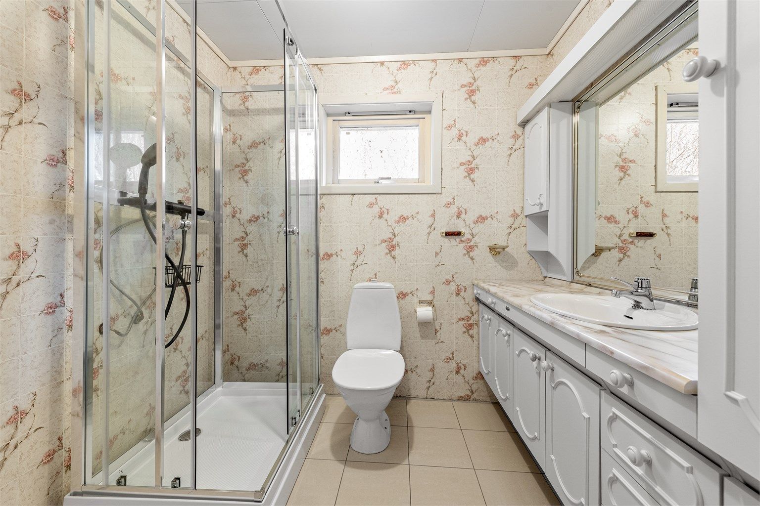 Badet i hovedetasjen er fra byggeåret og har flislagt gulv med gulvvarme, dusjkabinett og servantinnredning