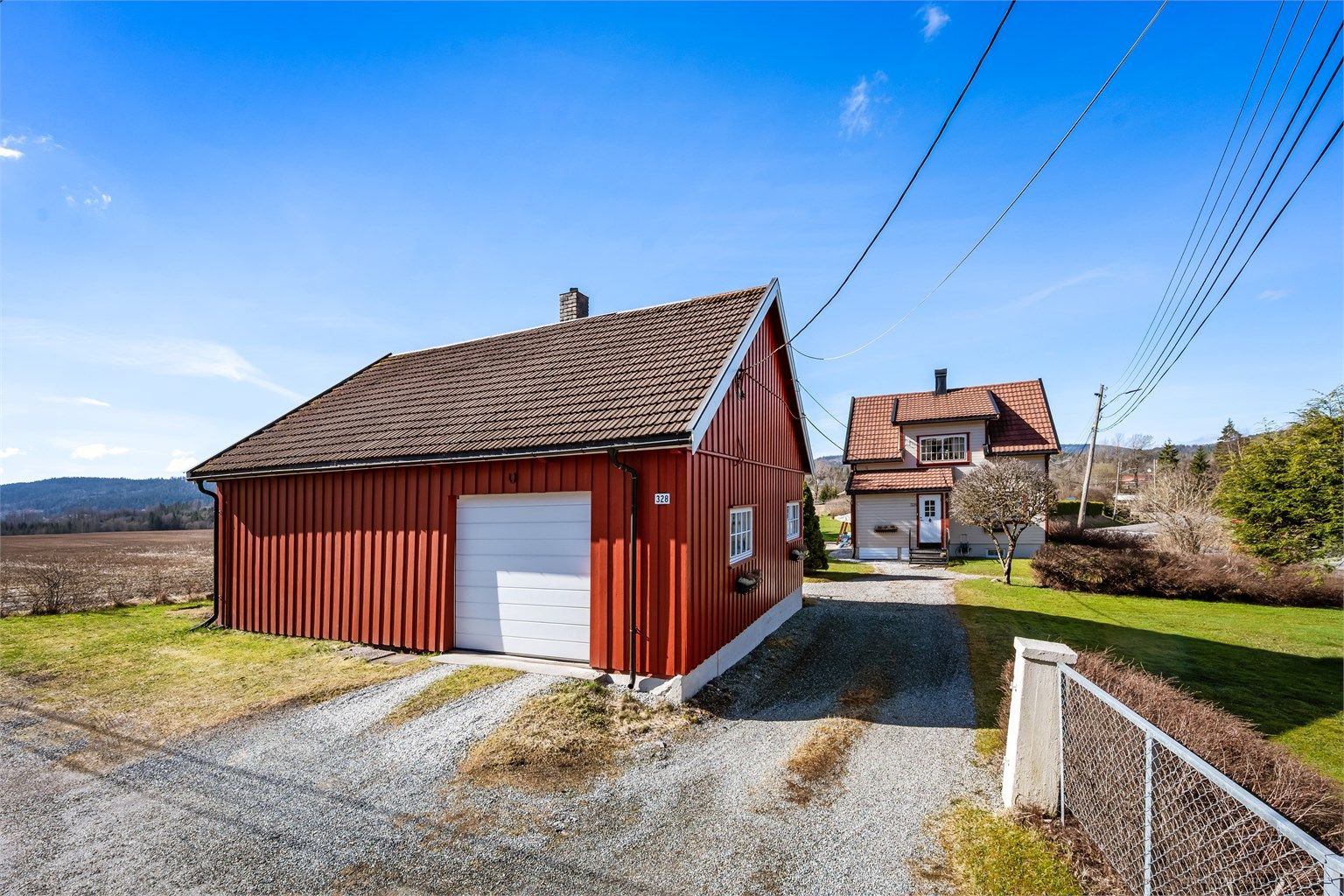 Uthuset fra 1932 har stående trekledning og tak med takstein.