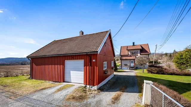 Uthuset fra 1932 har stående trekledning og tak med takstein.