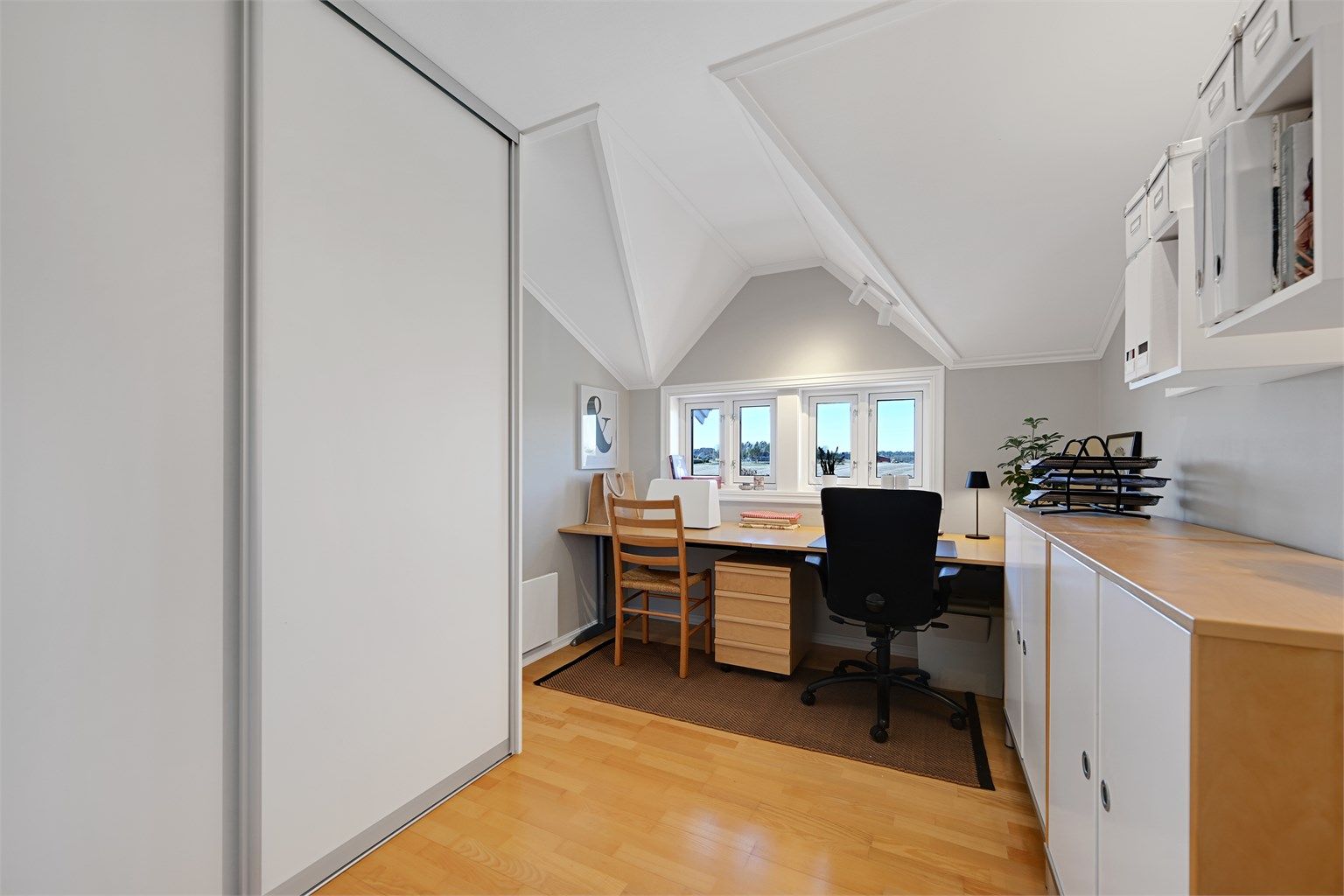 Et av rommene i andre etasje er innredet som kontor, med plassbygd skrivepult og skyvedørsgarderobe.