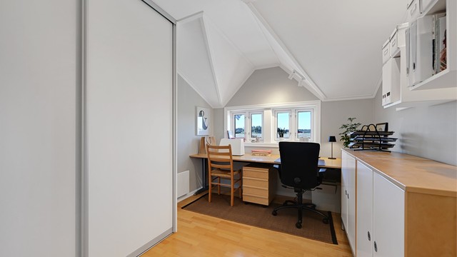 Et av rommene i andre etasje er innredet som kontor, med plassbygd skrivepult og skyvedørsgarderobe.