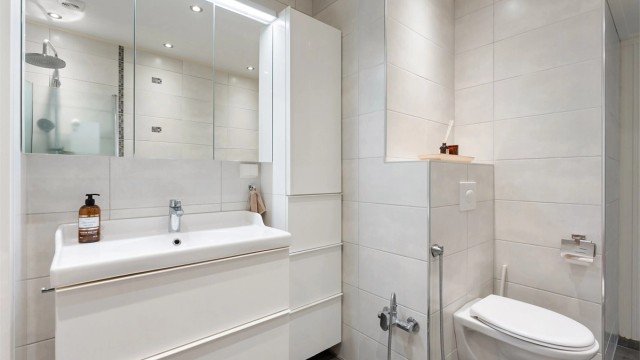 Badet er utstyrt med vegghengt toalett, dusjhjørne og servantinnredning med god oppbevaring.