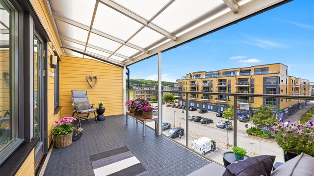Uteplassen har rekkverk i glass og metall, og levegger i trepanel.