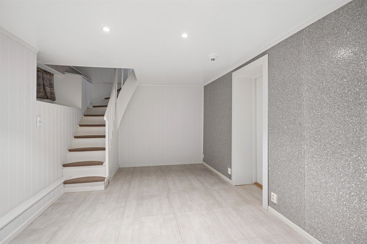 I boligens kjelleretasje har du en hyggelig kjellerstue, som kanskje kan benyttes som hobby-rom eller TV-stue (ikke godkjent/omsøkt til varig opphold).