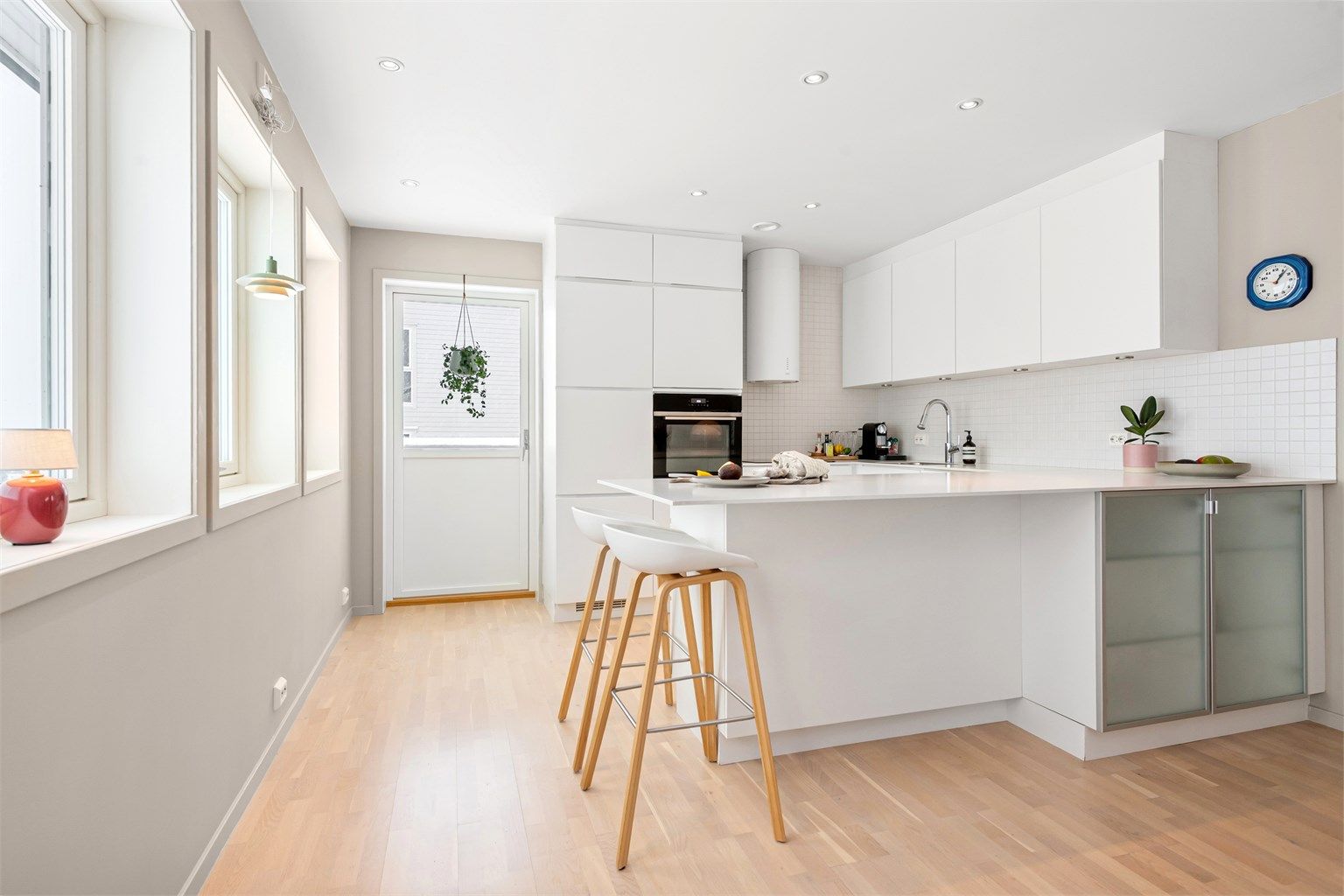 Kjøkkenet har en stilren innredning fra Kvik med slette fronter og en praktisk kjøkkenøy.