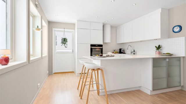 Kjøkkenet har en stilren innredning fra Kvik med slette fronter og en praktisk kjøkkenøy.