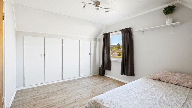 Romslig soverom på loftet med laminatgulv og god plass til garderobeløsning.