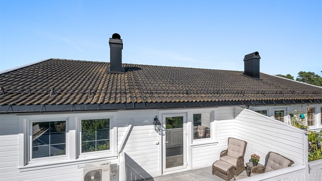 Balkongen er bygget i trekonstruksjoner med terrassebord på gulvet. Levegg som sørger for god skjerming.