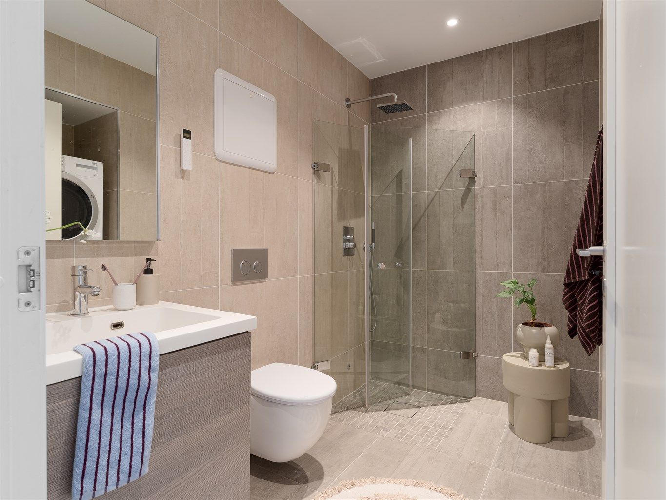 Lekkert bad fra 2015, flislagt med lekre storformatfliser som gir rommet et sømløst og eksklusivt uttrykk.