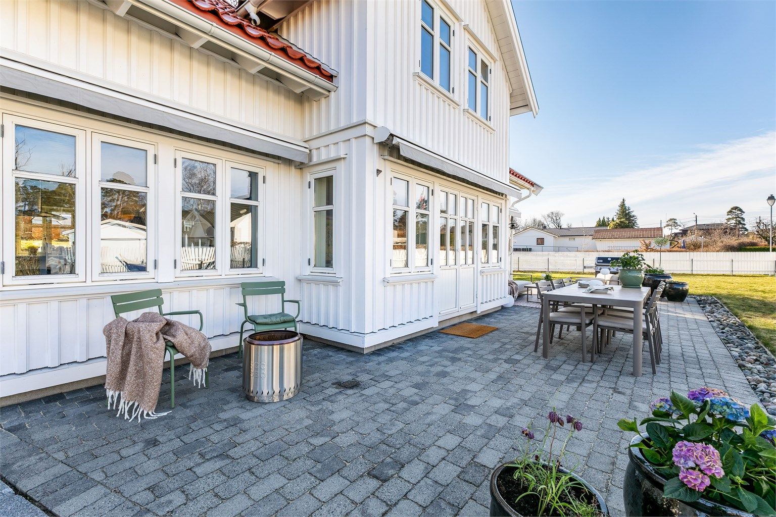 Det er lagt belegningsstein rundt hele boligen som danner en sammenhengende, stor og lettstelt uteplass.