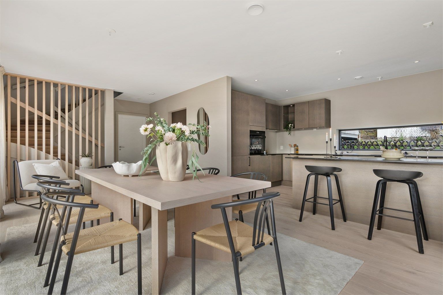 Kjøkken og spisestue med utgang til terrasse og hage. Huset har en god og gjennomtenkt planløsning som åpner for flere bruksmuligheter, og appellerer til familier med behov for fleksible løsninger der ulike generasjoner kan få spillerom