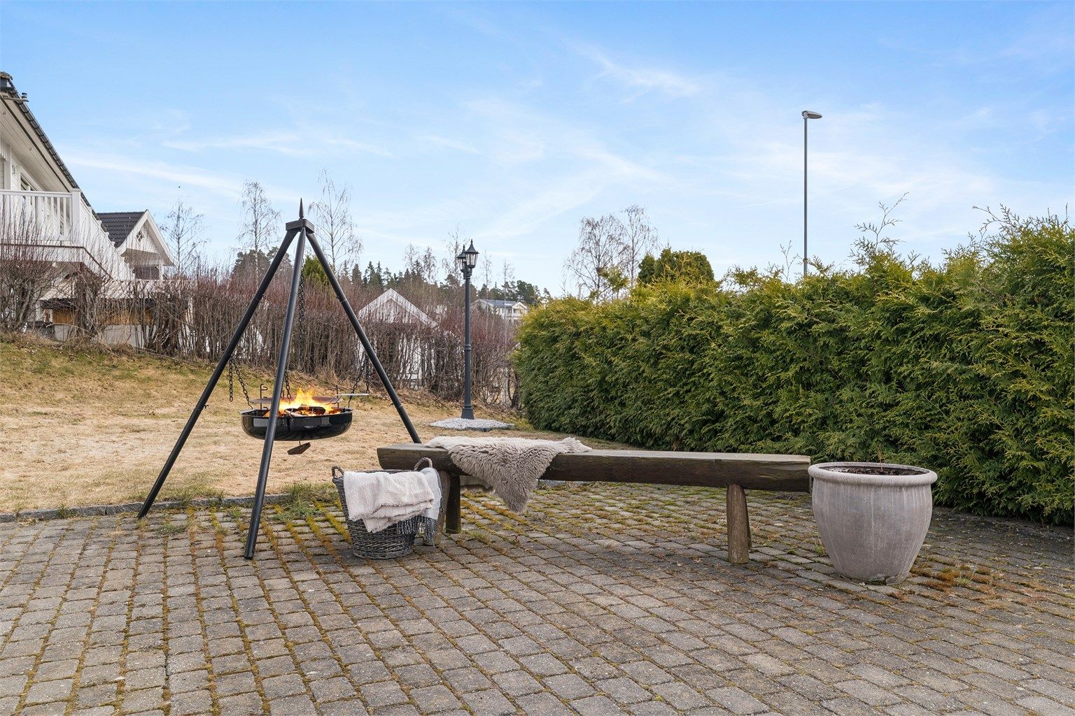 Uteområdet er pent opparbeidet med en romslig gårdsplass belagt med belegningsstein, fine plenarealer og hekker rundt eiendommen.