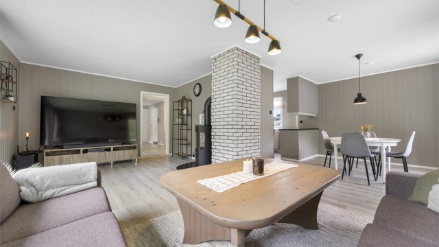 Åpen løsning mellom stue og kjøkken gir en sosial og luftig romfølelse.