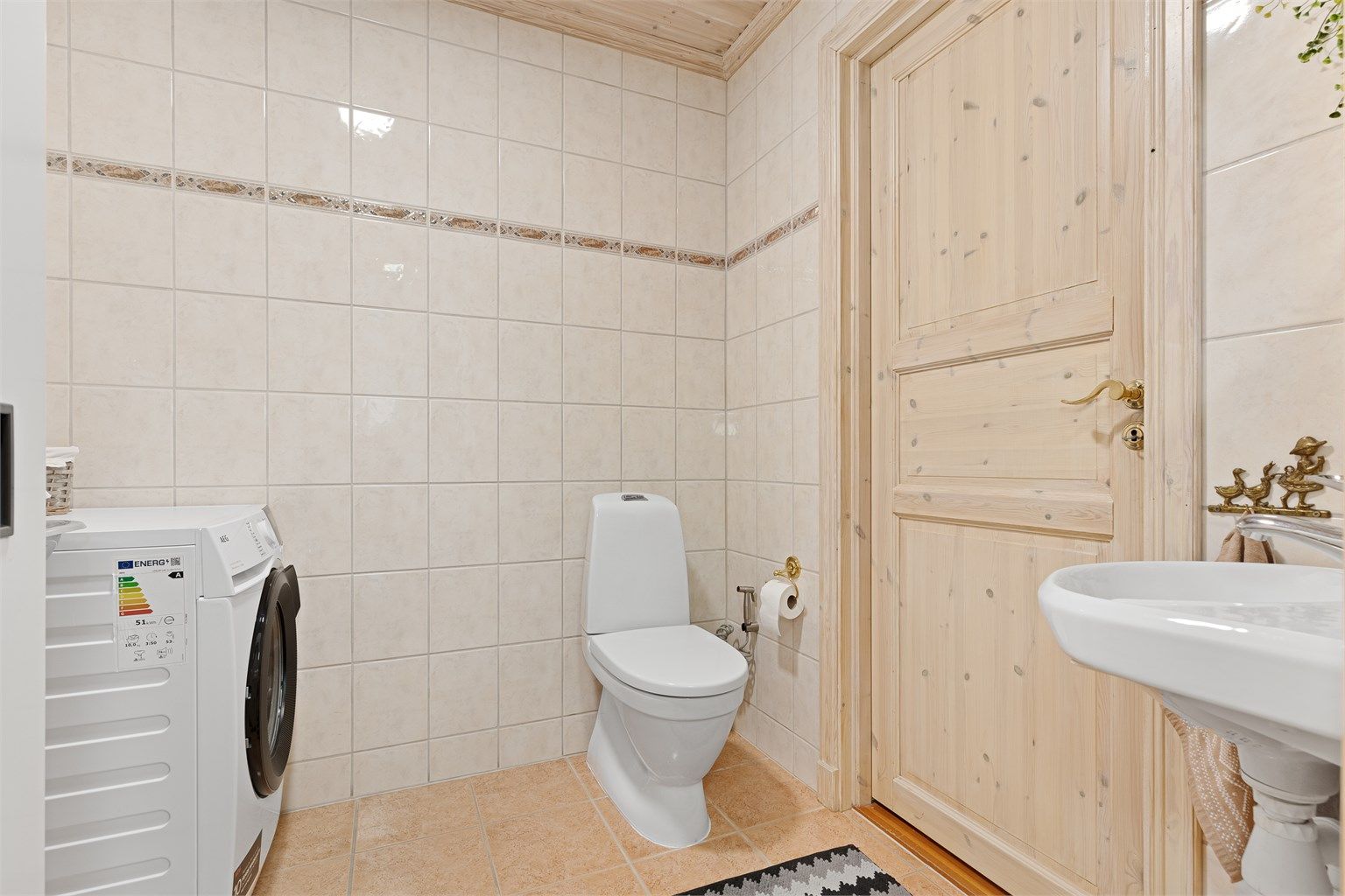 Første etasje inneholder også et praktisk vaskerom med toalett. Innenfor vaskerommet er det en god bod med varmtvannsbereder