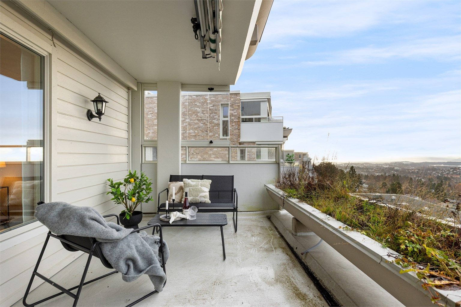 Det er montert markise, i tillegg er terrassen delvis overbygget og det er satt opp glassvegg på enden som skjermer for vær og vind