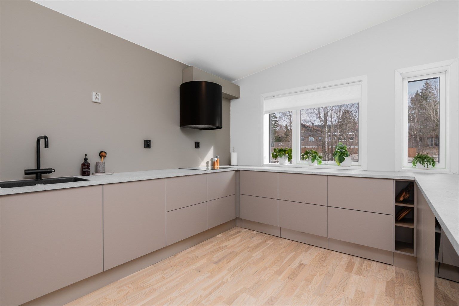 Kjøkkenet har har lyse slette flater og benkeplate av laminat samt rikelig med skap- og benkeplass å boltre seg på