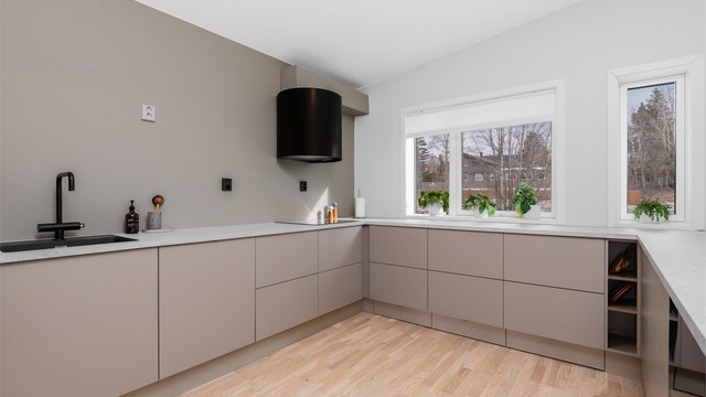 Kjøkkenet har har lyse slette flater og benkeplate av laminat samt rikelig med skap- og benkeplass å boltre seg på