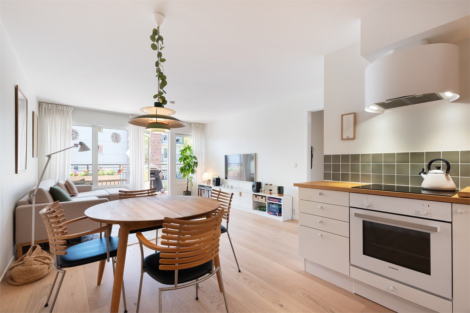 Det er naturlig plass til spisebord mellom stuen og kjøkkenet.