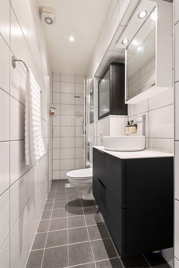 Badet har et praktisk dusjhjørne med innfellbare glassdører.