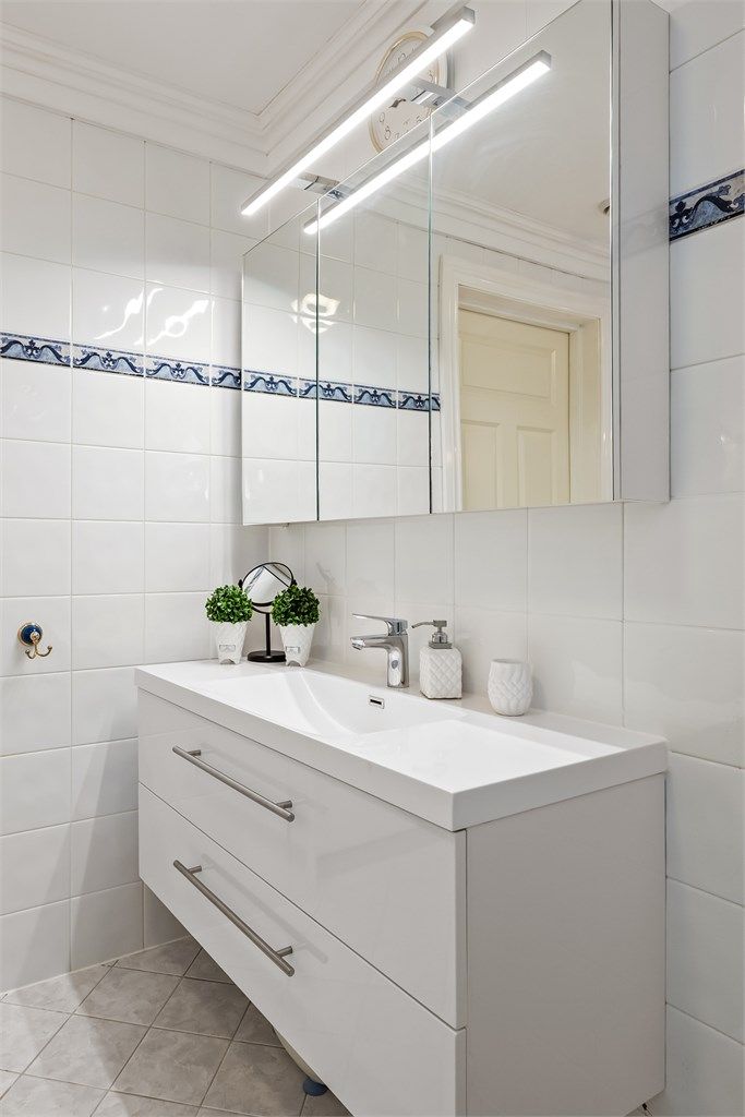 Badet har en moderne servantinnredning og speilskap med integrert belysning og stikkontakt.