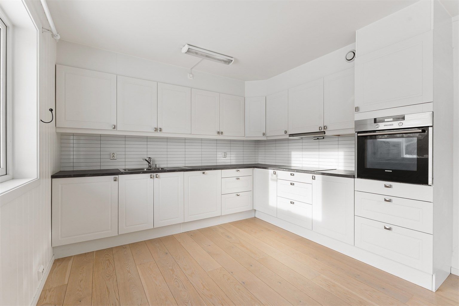 Leiligheten har et stort kjøkken i klassisk design fra Sigdal. Her er det integrert stekeovn i god arbeidshøyde og nedfelt platetopp.