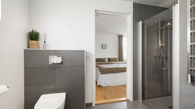 Badet er utstyrt med vegghengt toalett og dusjnisje med glassdør