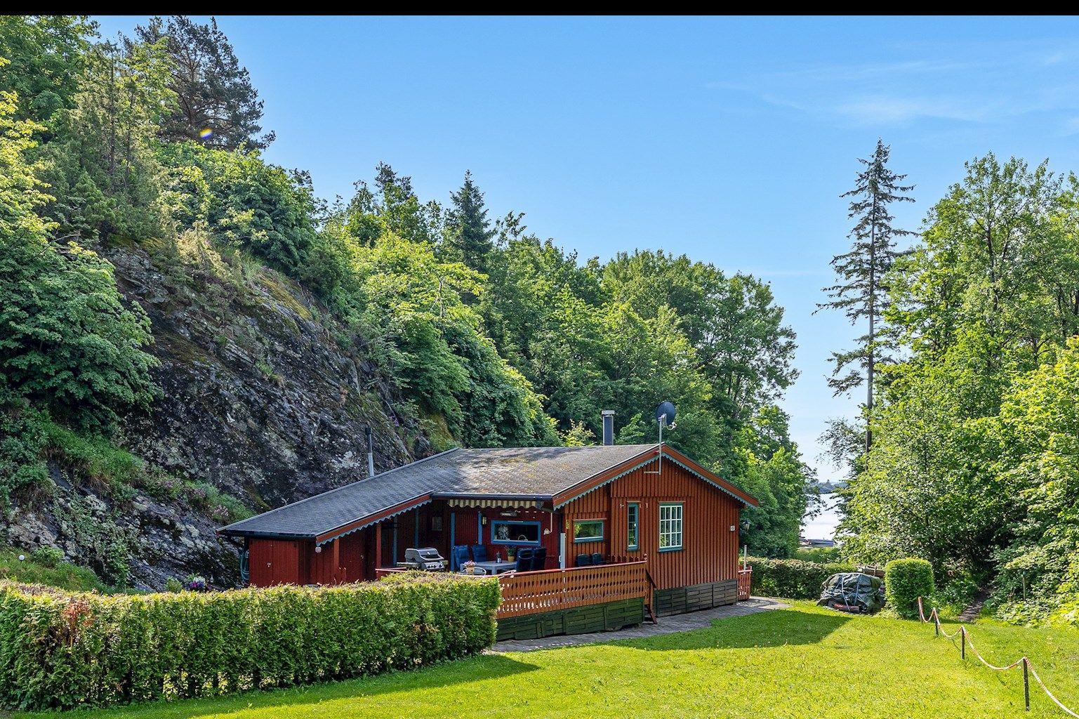 Hytta ligger helt for seg selv med utsikt ned mot stranda og utover sjøen.