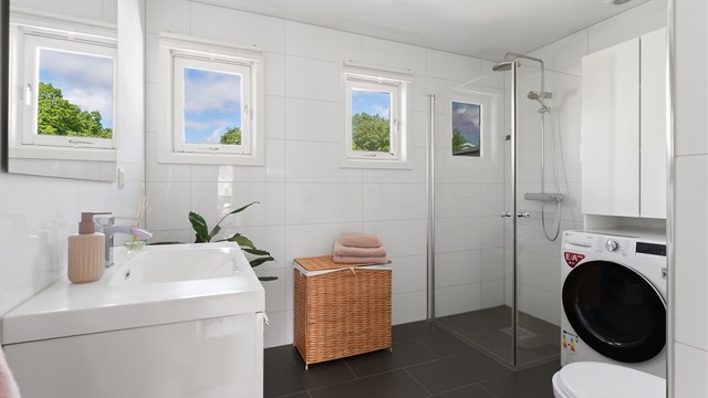 Delikat baderom fra 2018 med fliser på gulv med gulvvarme, fliser på vegger og nedsenket himling med downlights