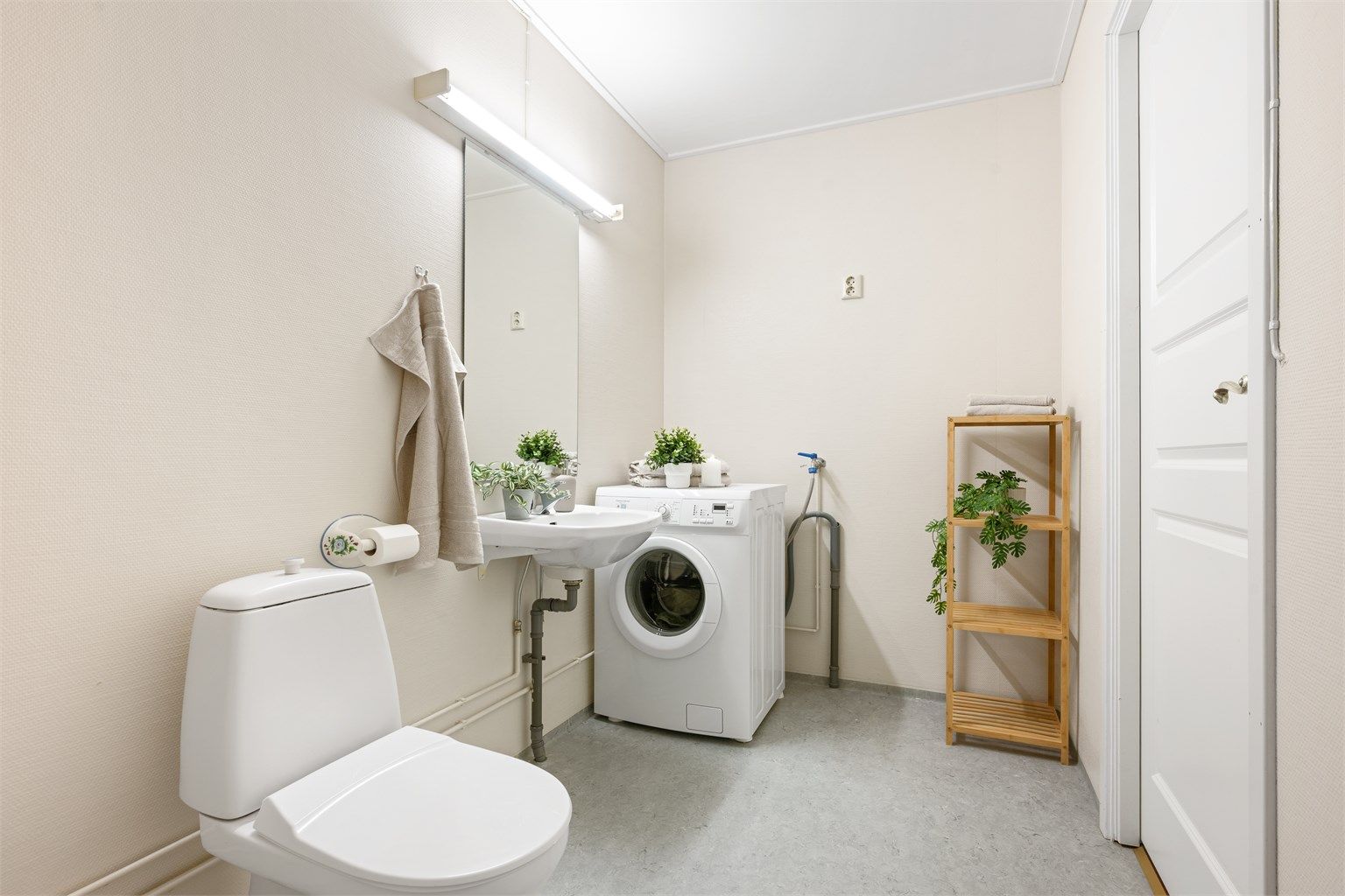 Badet er lyst og romslig, med dusj hjørne og opplegg for vaskemaskin.