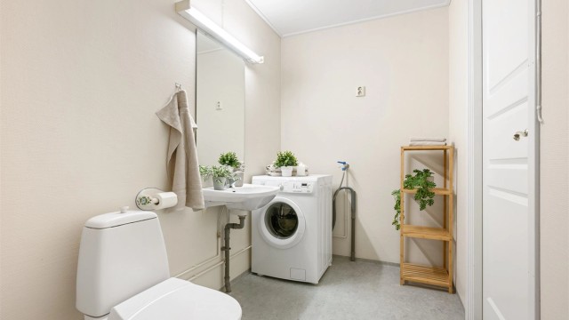 Badet er lyst og romslig, med dusj hjørne og opplegg for vaskemaskin.