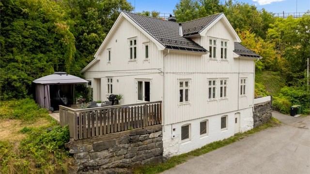 Det hvitmalte og sjarmerende huset ligger idyllisk til i Brevik.