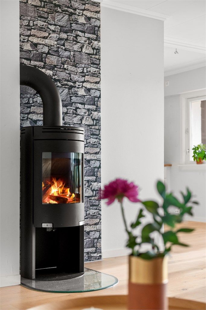 Flott peisovn med glassdør i stuen som gir en lun og hyggelig atmosfære