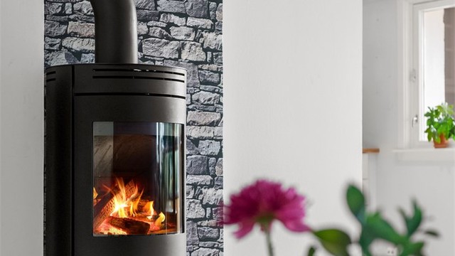Flott peisovn med glassdør i stuen som gir en lun og hyggelig atmosfære