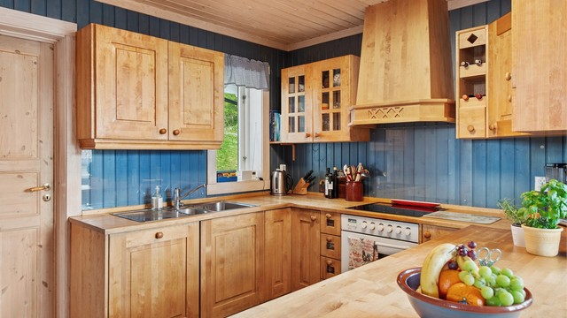 Heltre kjøkkeninnredning med profilerte fronter, nedfelt oppvaskkum og integrert stekeovn og platetopp.