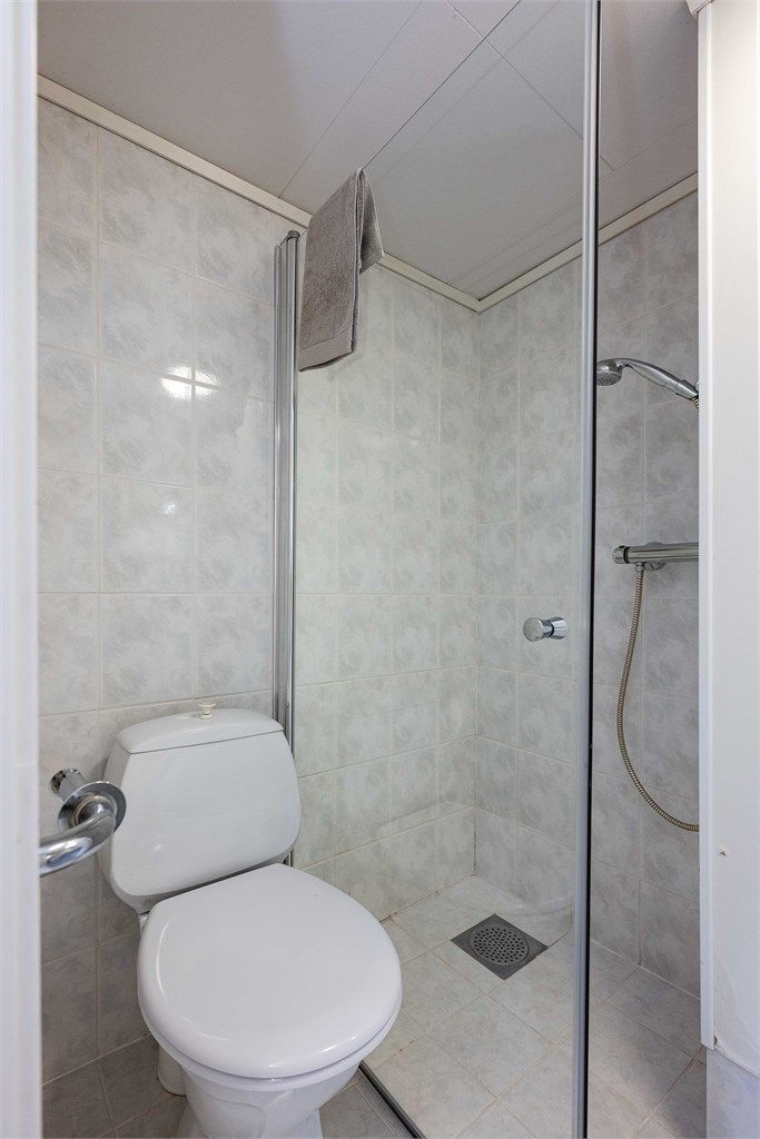 Badet har flislagt gulv med gulvvarme og dusjhjørne. Badet har et oppgraderingsbehov.