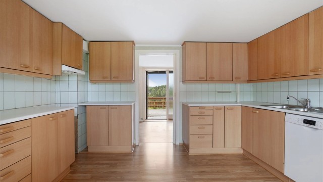 Kjøkkeninnredning med slette fronter og laminat benkeplate.