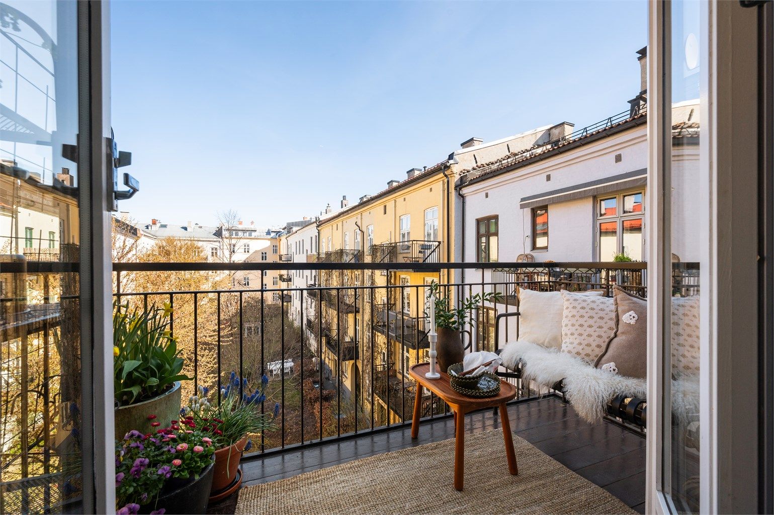 Balkongen vender mot den rolige, frodige bakgården og blir en forlengelse av kjøkkenet – et privat pusterom midt i byens puls.