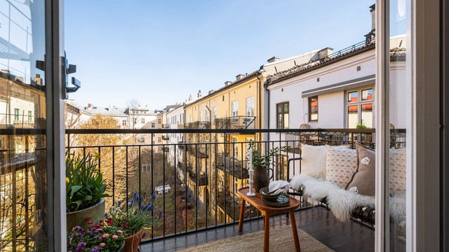 Balkongen vender mot den rolige, frodige bakgården og blir en forlengelse av kjøkkenet – et privat pusterom midt i byens puls.