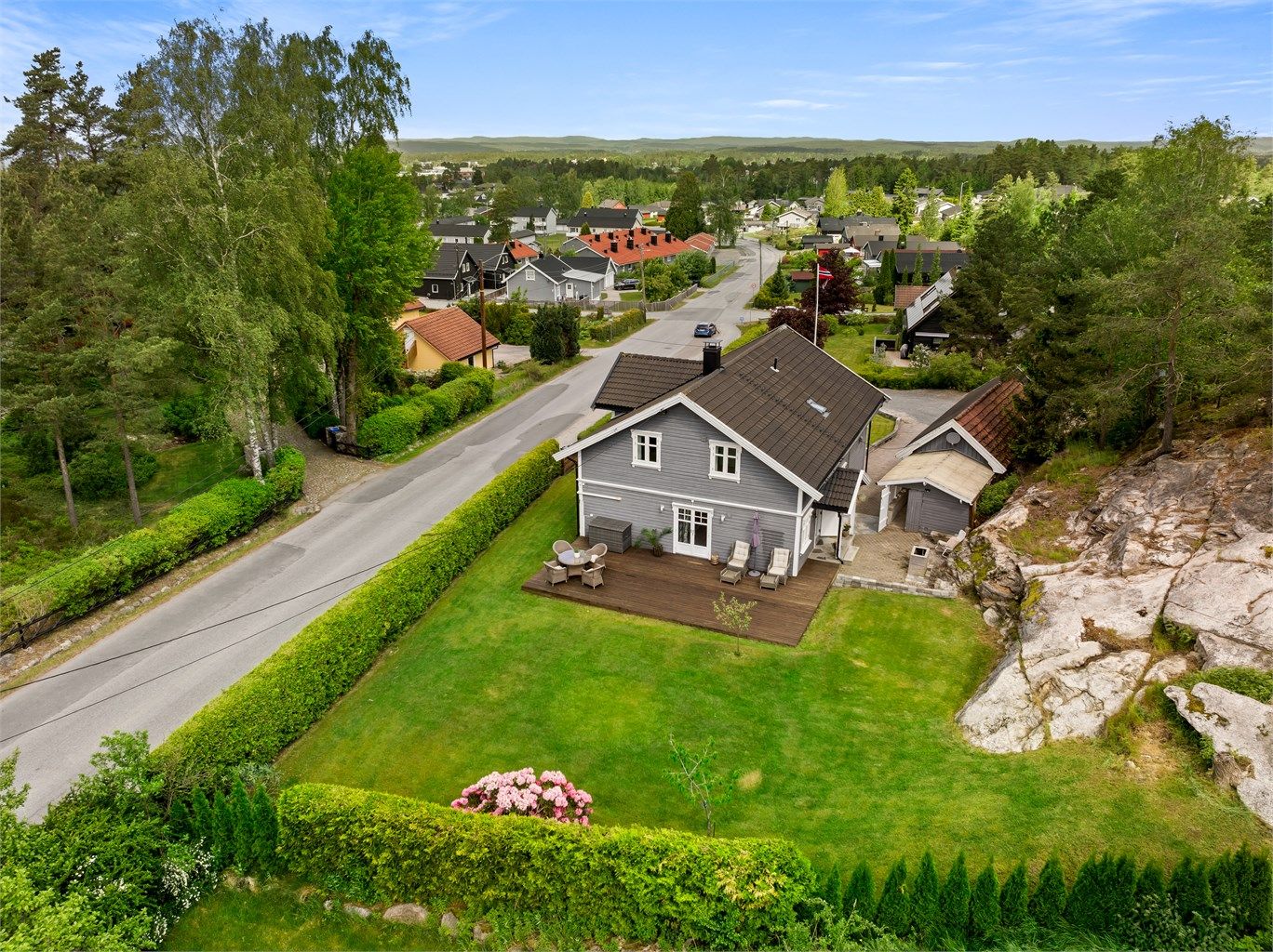 Den store, men lettstelte hagen rammes pent inn av en tettvoksende og veltrimmet hekk.