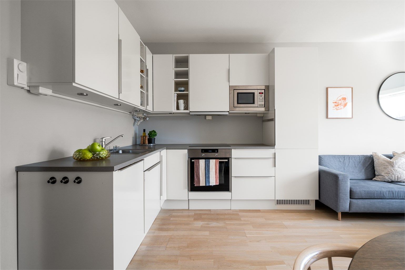 Kjøkkenet fra HTH har en åpen løsning mot stuen og er utstyrt med integrerte hvitevarer, inkludert induksjonstopp, stekeovn og mikrobølgeovn.