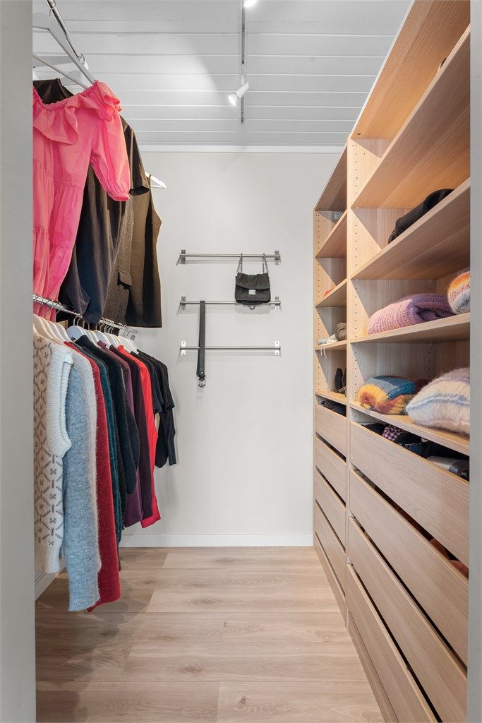 Walk-in-closet inredet med innredning fra IKEA og praktisk heng på andre siden.