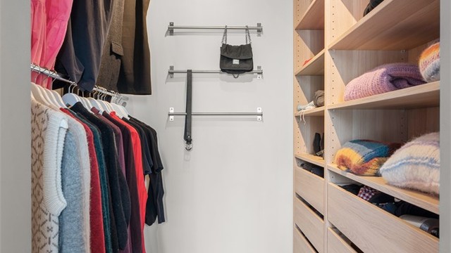 Walk-in-closet inredet med innredning fra IKEA og praktisk heng på andre siden.