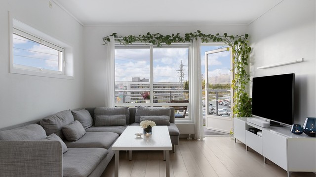 Romslig stue med god plass til sofagruppe og tilhørende møblement.