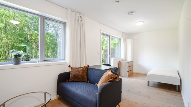 Hybeldelen har en åpen løsning med plass til både sittegruppe og soveplass.