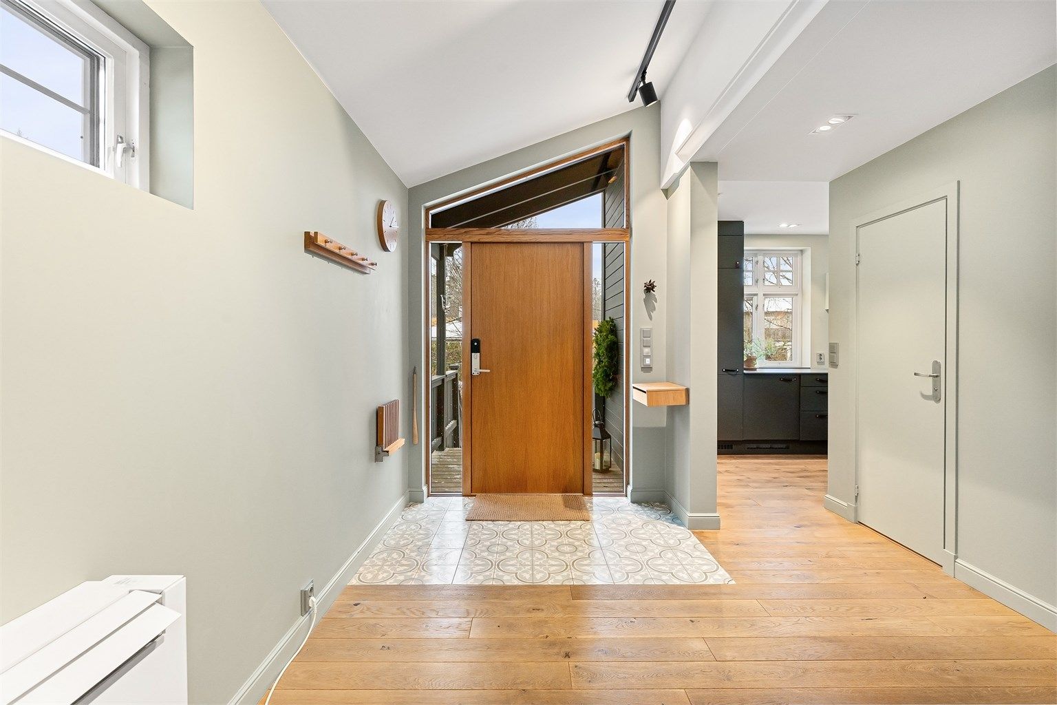 Velkommen inn i en lys og romslig entré med dekorative gulvfliser.