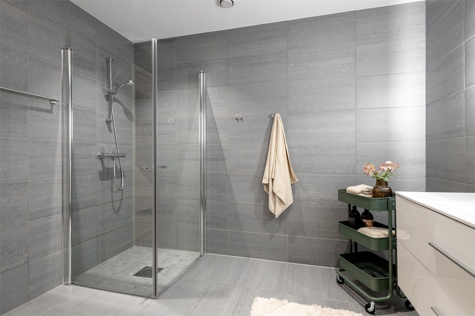 Badet har dusjhjørne med innfellbare glassdører.